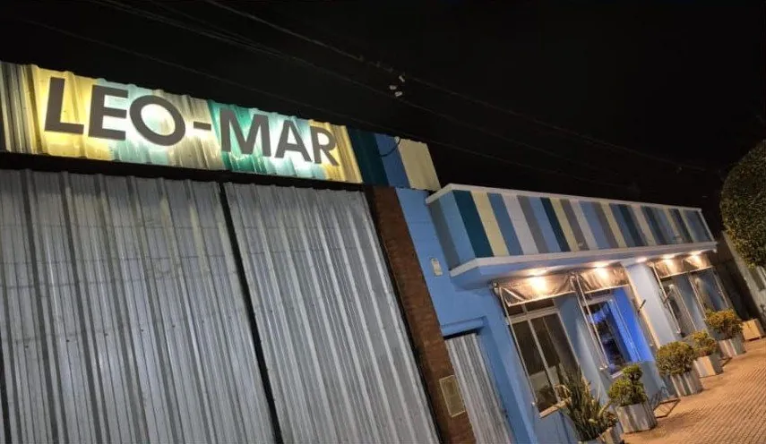 Frente del local de Leo-Mar en Las Rosas, de noche, con el cartel iluminado